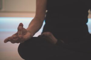 Neurowellness: la tecnología que aprende a calmar tu sistema nervioso Persona en calma con dispositivo de bienestar cerca del cuello, luz natural suave, estética editorial minimalista