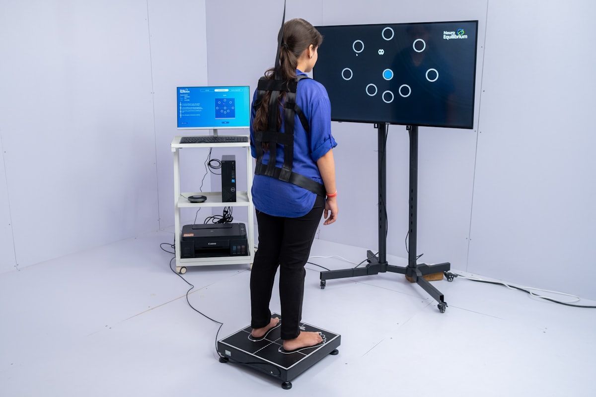 Detalle de una persona usando un dispositivo de biofeedback con auriculares, ambiente cálido y natural