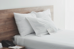 El hotel que diseña el descanso: cómo la arquitectura mejora tu recuperación Habitación de hotel minimalista con cama blanca y luz natural suave