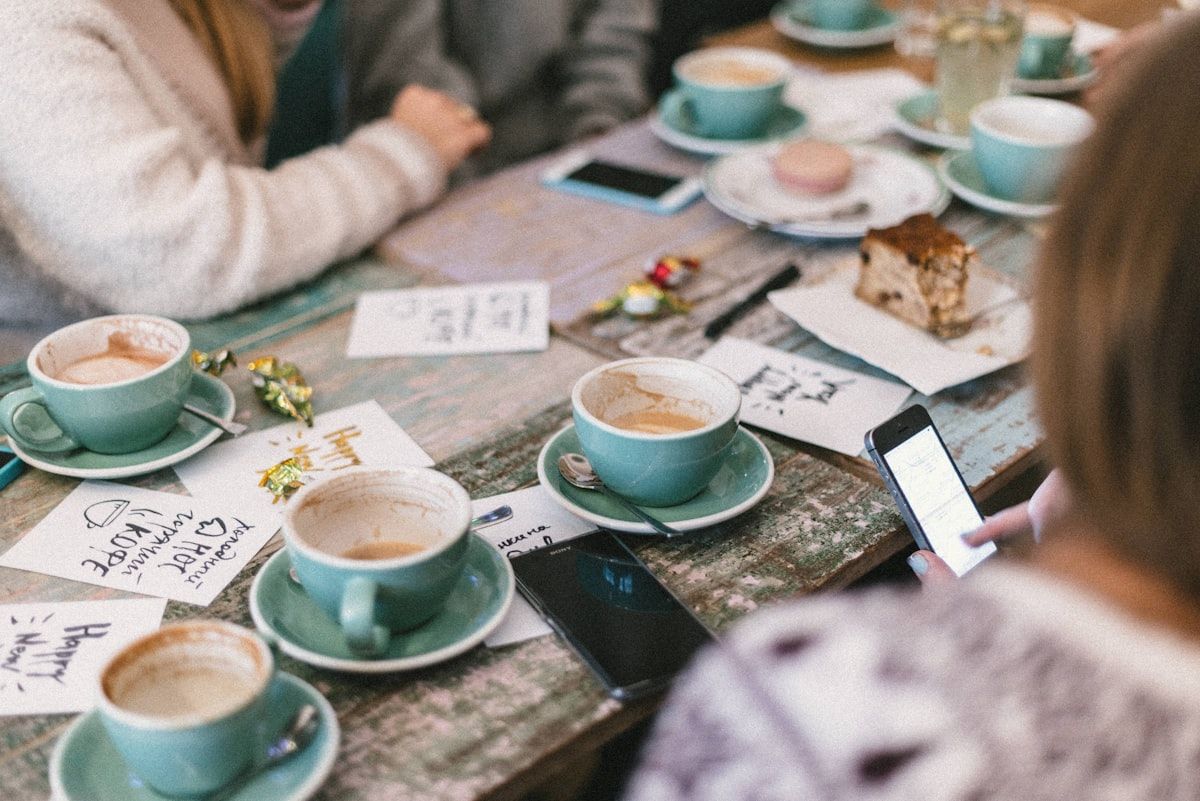 Grupo de personas reunidas en una mesa conversando, ambiente relajado sin alcohol