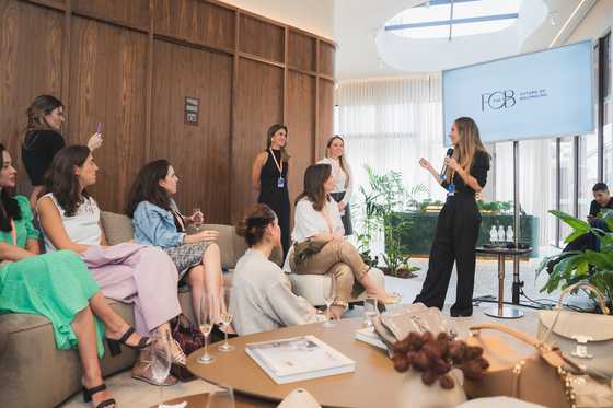 Sari B. Stad hablando frente a un grupo de mujeres reunidas en un encuentro de The F.O.B, comunidad de pertenencia y bienestar