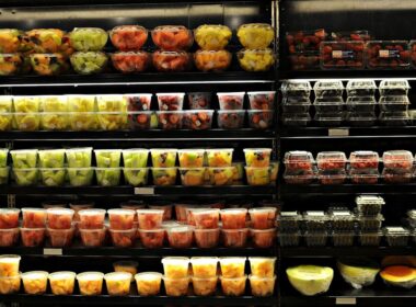 Carrito de supermercado con frutas frescas, yogur y proteínas, composición editorial