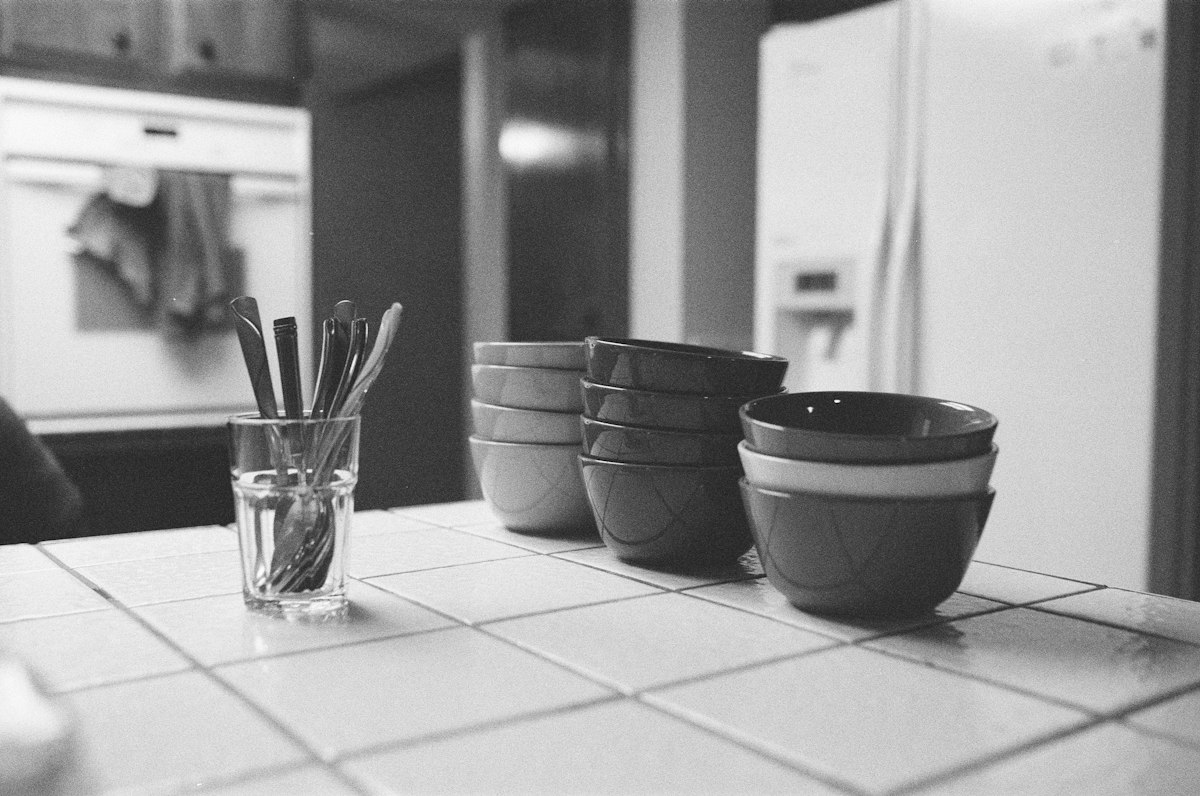 Manos preparando un guiso casero a fuego lento, cocina reconfortante y consciente.