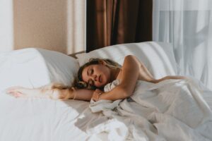 Mouth taping: la tendencia de sueño que crece en Google, y lo que la evidencia no confirma Mujer durmiendo tranquila cubierta con manta azul