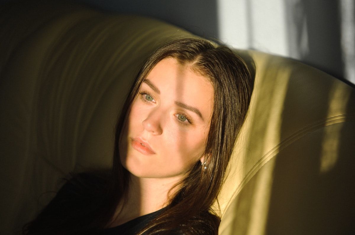 Rostro de mujer con luz natural y sombras de hojas