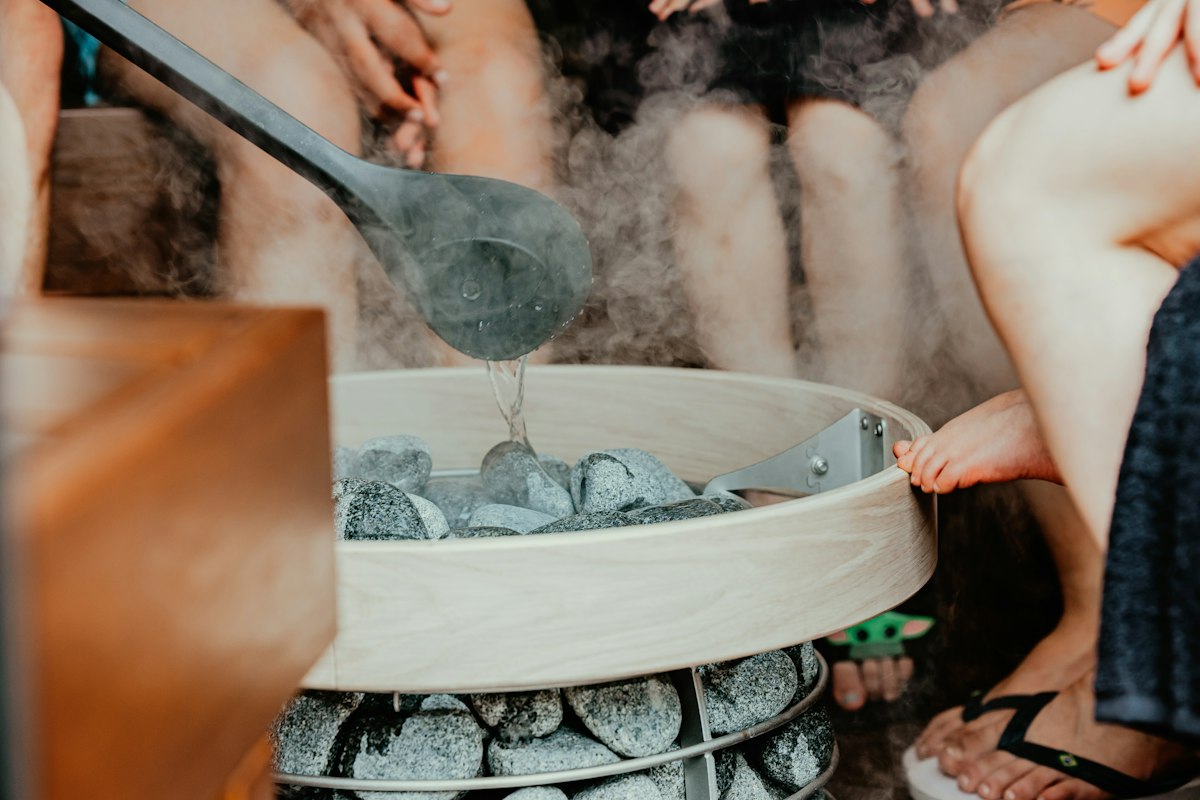 Espacio de recuperación con tina de inmersión fría y sauna, ambiente editorial premium.